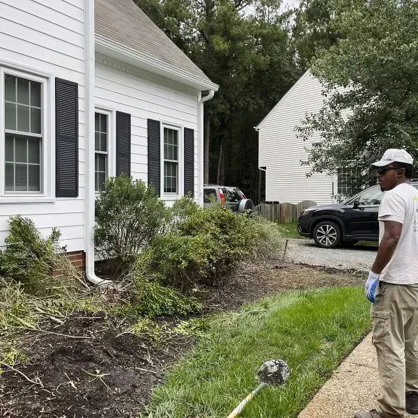 A Professional Standing In Front Of A House With A Lawn, Inspecting The Area Before Brush Removal Or Brush Cutting