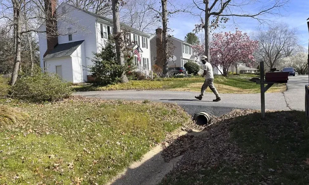 A professional walking by a fall cleanup area for doing initial inspection of the entire site to